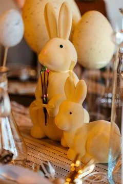 Festive Easter table setting with cute bunny decorations, pastel eggs, and warm Stock Photos