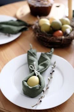 Festive Easter table setting with Easter bunny made of linen napkin and egg. Top Stock Photos