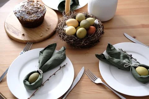 Festive Easter table setting with Easter bunny made of linen napkin and egg Stock Photos