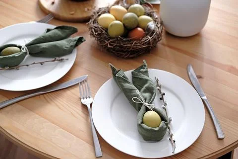 Festive Easter table setting with Easter bunny made of linen napkin and egg. Top Stock Photos