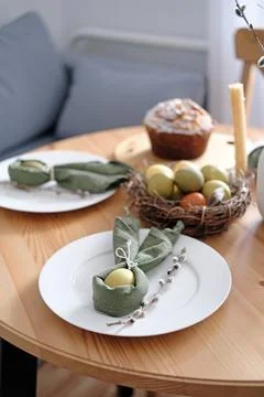 Festive Easter table setting with Easter bunny made of linen napkin and egg Stock Photos