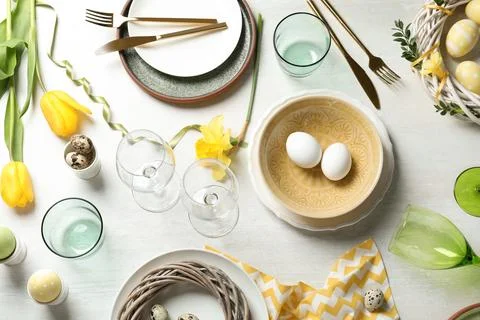 Festive Easter table setting with eggs on wooden background, top view Stock Photos