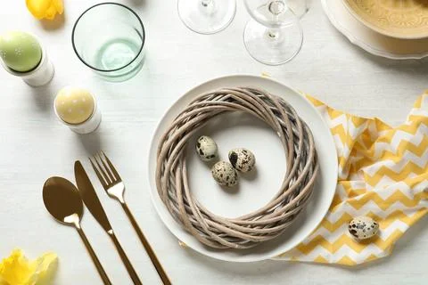 Festive Easter table setting with eggs on wooden background, top view Stock Photos