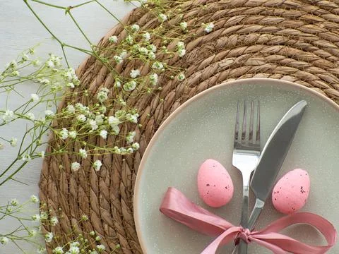 Festive Easter table setting with eggs and flowers on brown background Stock Photos