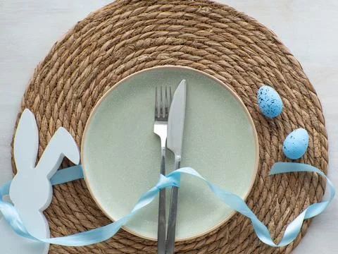 Festive Easter table setting with eggs and bunny on brown background Stock Photos