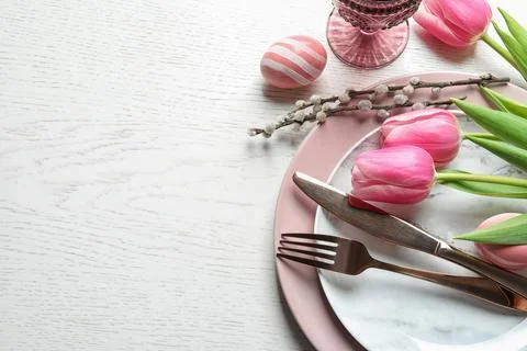 Festive Easter table setting with flowers on wooden background, above view. S Foto stock
