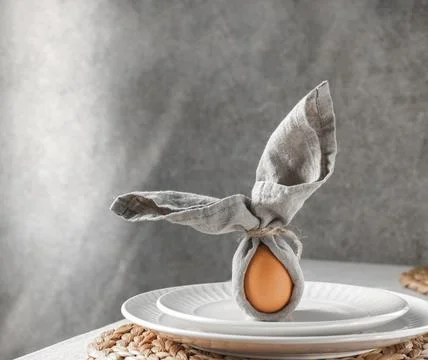 Festive Easter table setting. Funny Easter bunny made of egg and linen napkin Fotos Stock