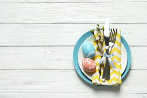 Festive Easter table setting with painted eggs on wooden background, top view Stock Photos