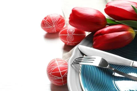 Festive Easter table setting with painted eggs on wooden background, space fo Stock Photos