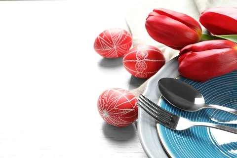 Festive Easter table setting with painted eggs on wooden background, space fo Stock Photos