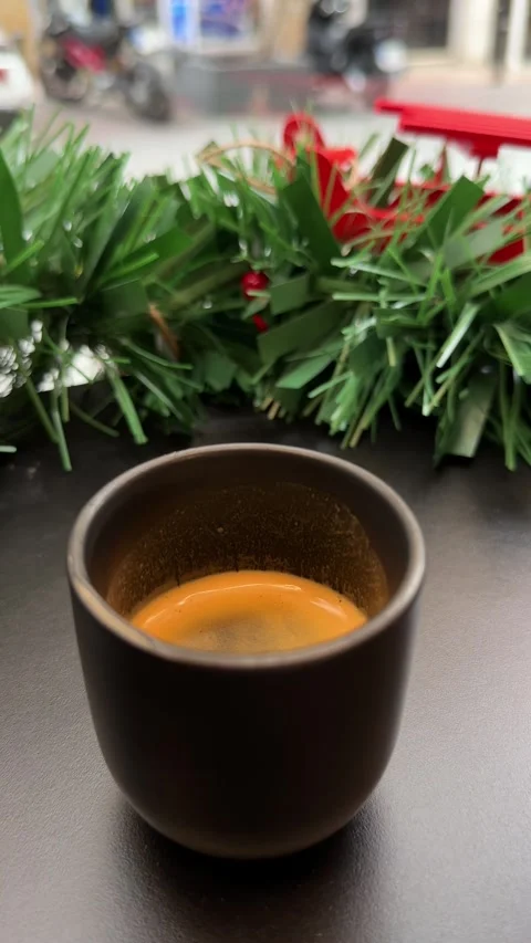 Festive espresso cup on table with Christmas-themed decorations in urban café Stock Footage 294821355