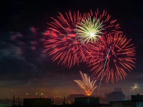 Festive firework bursts in the midnight sky. Red white fireworks. Stock Photos