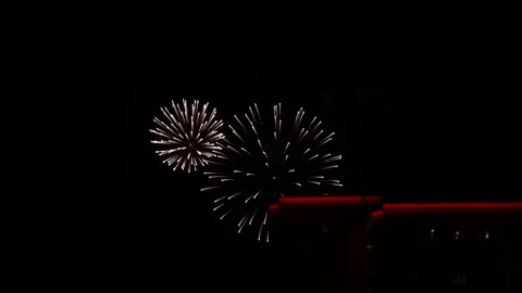 Festive fireworks display over city buildings at night Stock Footage 334127922