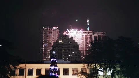 Festive fireworks explode among the night high-rise buildings Stock Footage 239296746