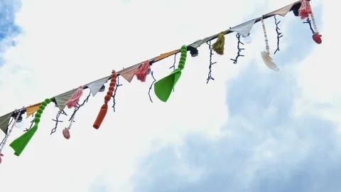 Festive flags and decorations on a rope swing in the wind Видео 336381963