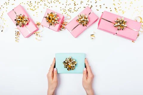 Festive flat lay composition woman's hands giving blue gift 库存照片