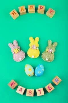 Festive flat lay with "Happy Easter" wooden blocks, cute felt bunnies, and .. Stock Photos