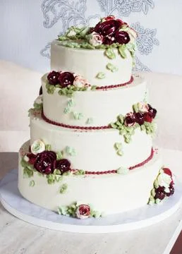 Festive four-level white elegant cake with cream flowers, wedding cake, cream Stock Photos