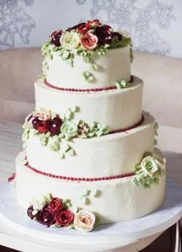 Festive four-level white elegant cake with cream flowers, wedding cake, cream Stock Photos