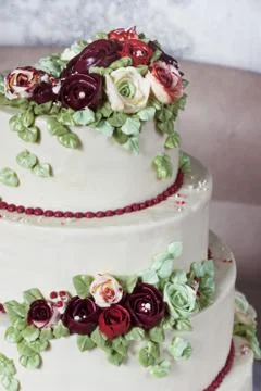 Festive four-level white elegant cake with cream flowers, wedding cake, cream Stock Photos