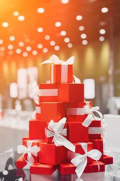 A festive gift arrangement of red boxes with white ribbons stands in the store 스톡 사진