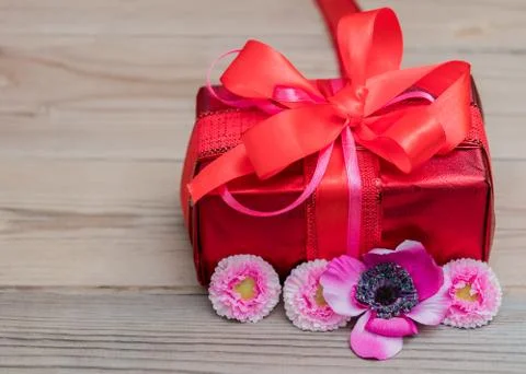 Festive gift box with a bow of red color. Lies on a white background. Next to Stock Photos