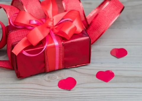 Festive gift box with a bow of red color. Lies on a white background. Next to Stock Photos