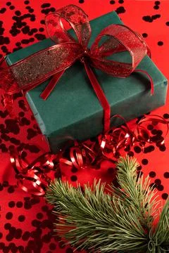 Festive gift box on a red background with sequins. Stock Photos