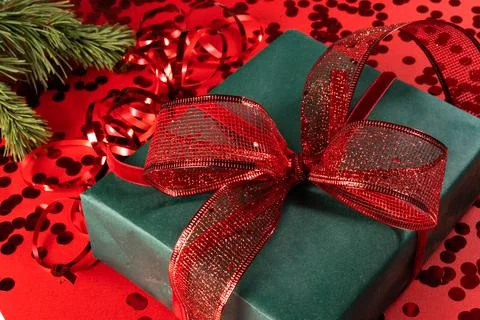 Festive gift box on a red background with sequins. Stock Photos