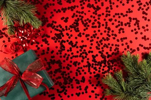Festive gift box on a red background with sequins. Stock Photos