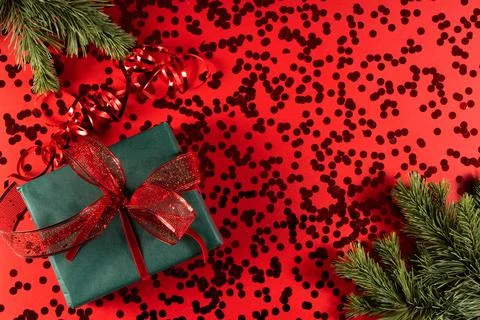 Festive gift box on a red background with sequins. Stock Photos