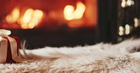 Festive Gift Box standing by the Burning Fireplace. 4K SLOW MOTION 120FPS Dolly Vidéo 69261414