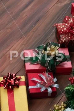 Festive gift boxes line up on wood board, decorate with pine branches and chr Stock Photos