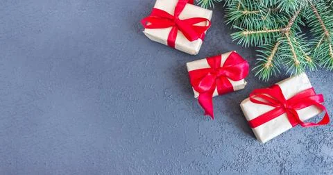 Festive gift boxes with spruce branches on concrete background. The concept o Stock Photos