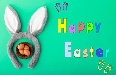 Festive Happy Easter greeting featuring fluffy bunny ears encircling a nest.. Stock Photos