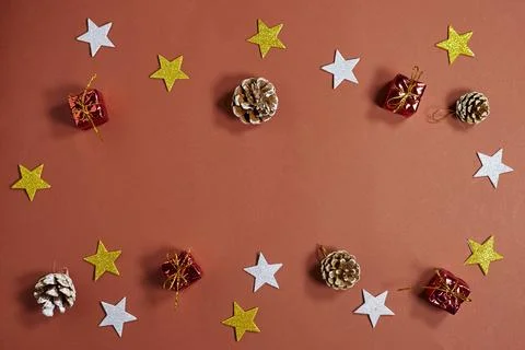 Festive Holiday Flat Lay With Pinecones, Stars, And Small Gift Boxes On Red Back Stock Photos