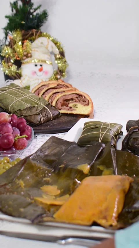 Festive holiday table featuring unwrapped tamales and sliced ham bread Stock Footage 332895300