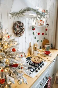 Festive kitchen setup with Christmas tree, pinecone wreath, and garland. Wooden Stock Photos
