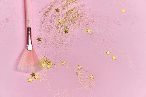 Festive magic make up brush on pink background. Stock Photos