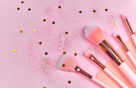 Festive magic make up brushes on pink background. Stock Photos