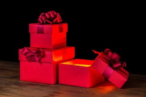 Festive opened boxes with bow and light on wooden background is isolated, clo 스톡 사진