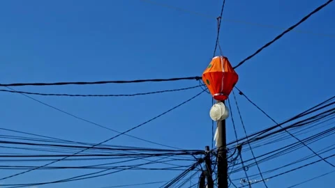 Festive orange decorative hanging lantern swinging against a clear blue sky.. Video stock 344360286