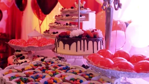 Festive party table with sweets and cake pastries and multicolor decorations  Video stock 305595008