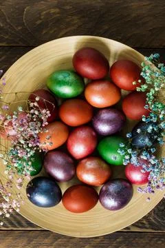 Festive plate with Easter bright eggs and spring flowers. top view. Stock Photos