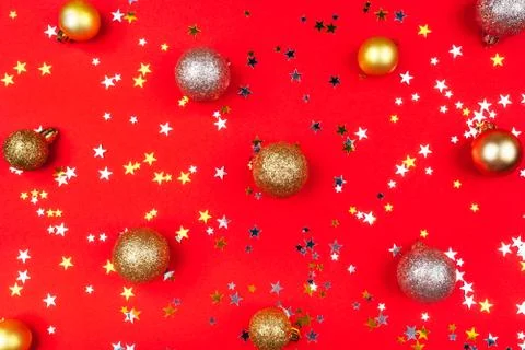Festive red background with gold and silver stars and Christmas balls. Stock Photos