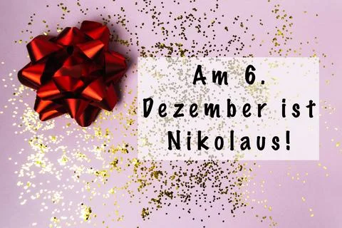 Festive red bow on purple background with glitter and text celebrating holiday Stock Photos