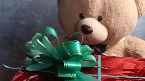 Festive red box with a green bow and toy teddy bear get a gift. Extraordinary Stock Footage 81178886