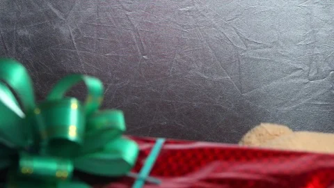 Festive red box with a green bow and toy teddy bear get a gift. Extraordinary Stock Footage 81179217