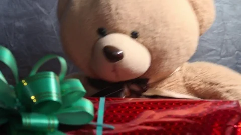 Festive red box with a green bow and toy teddy bear get a gift. Extraordinary Stock Footage 81179389