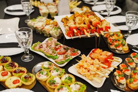 Festive restaurant banquet table layout filled with gourmet catering food Stock Photos